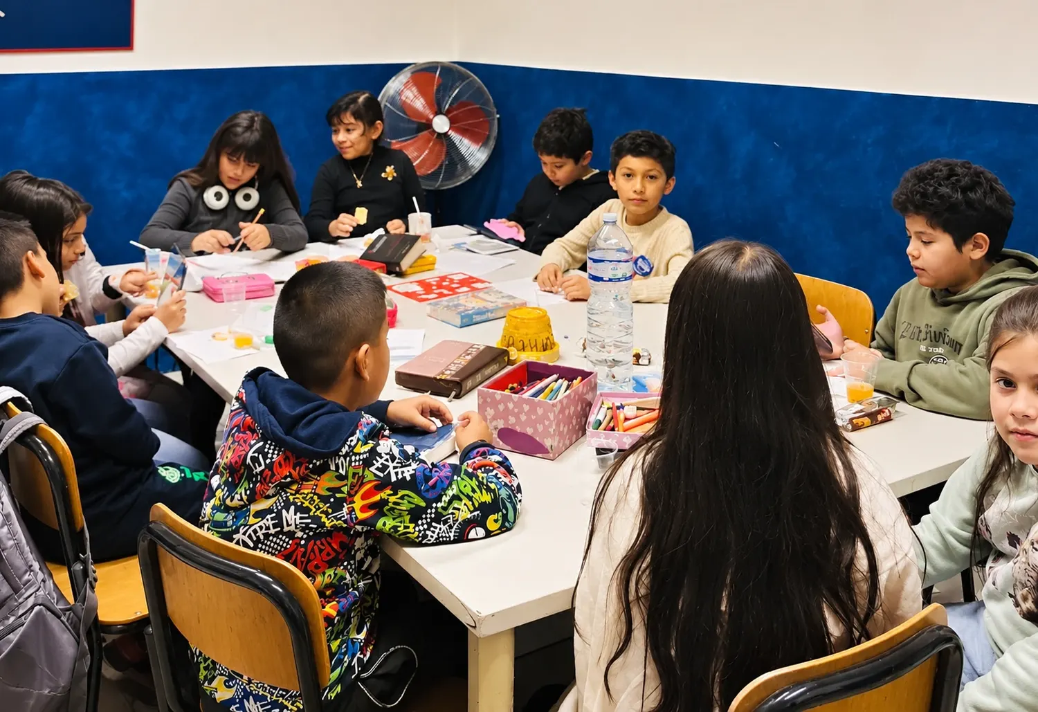 Bambini al tavolo con colori e lavoretti durante la Scuola Biblica